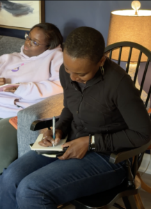 Two writers taking notes during a session at a writing retreat